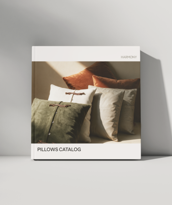Square catalog cover featuring multiple decorative pillows with button and tie accents, arranged in overlapping rows, viewed from the front.